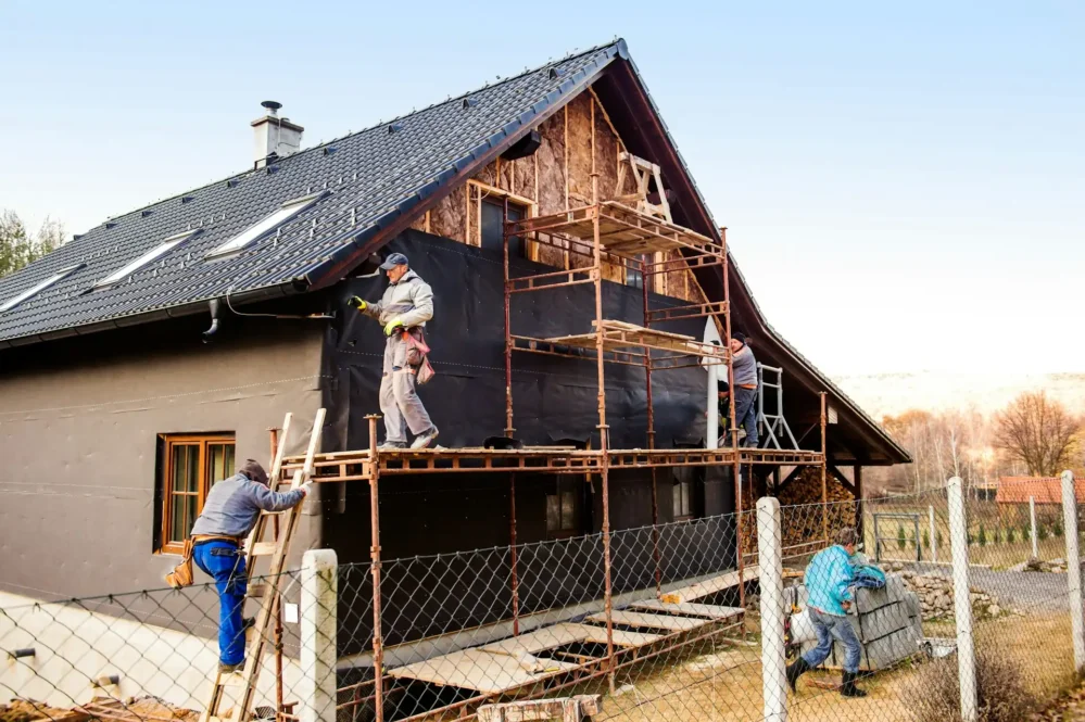 a team of contractors putting up siding on a house